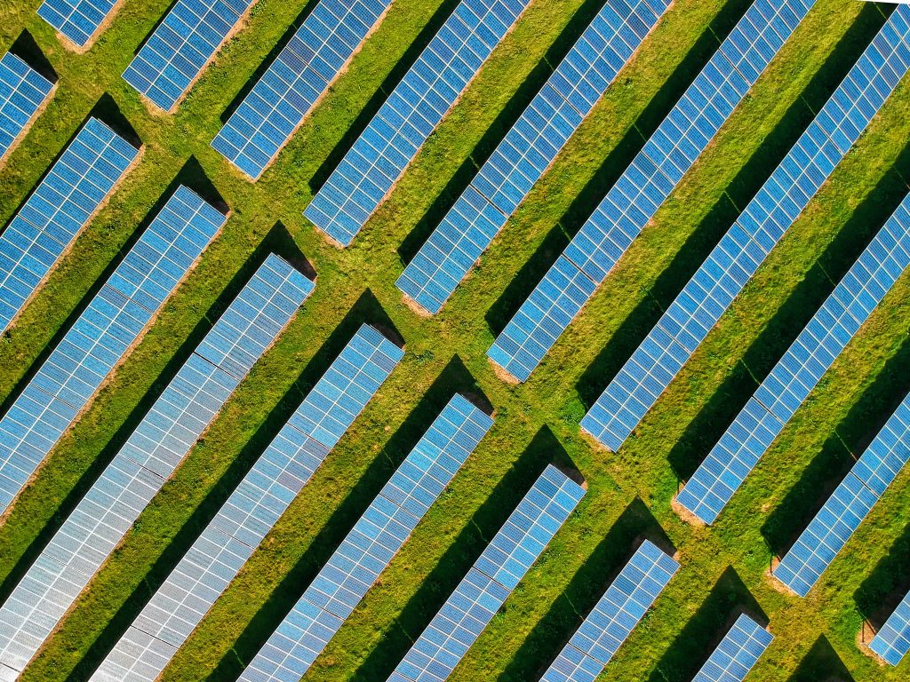 Solar panels on a green field representing an ISO 14001 environmental management system