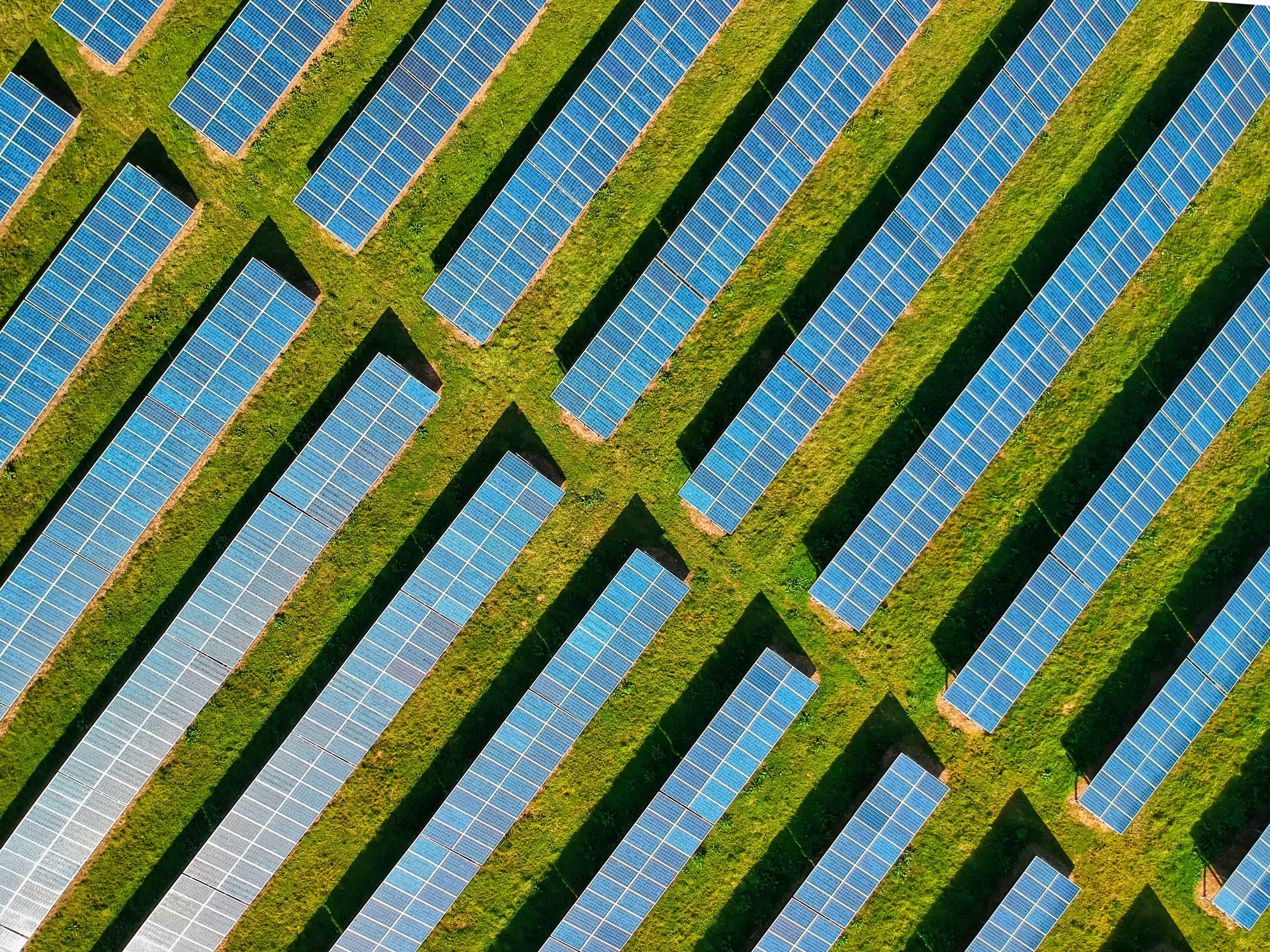 Solar panels on a green field representing an ISO 14001 environmental management system